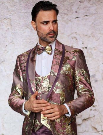 A man in an INSOMNIA DELMAS MAROON suit stands before a textured wall wearing a bow tie.