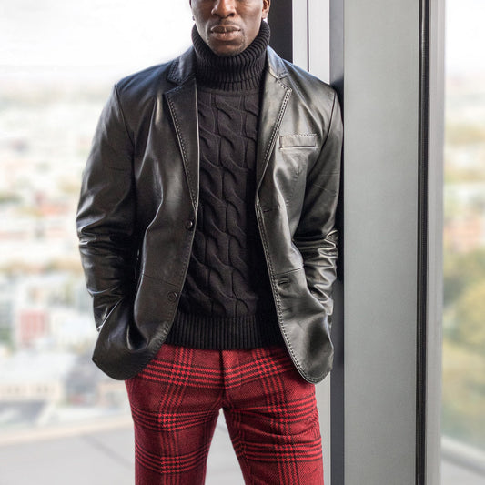 A person stands by a window wearing the Inserch Leather Blazer 600-01 Black by Inserch, paired with a black turtleneck sweater and red plaid pants.