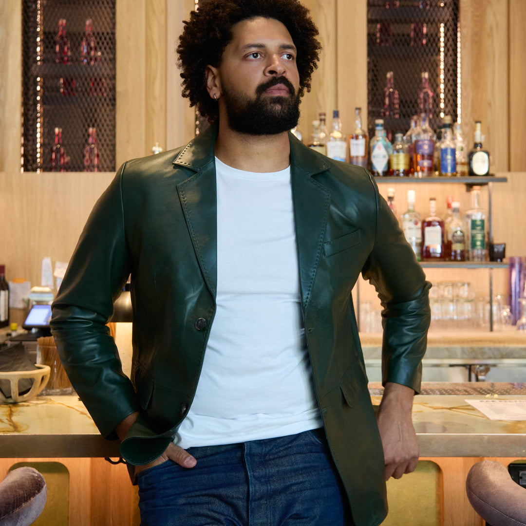 Man in a leather jacket standing in a bar setting
