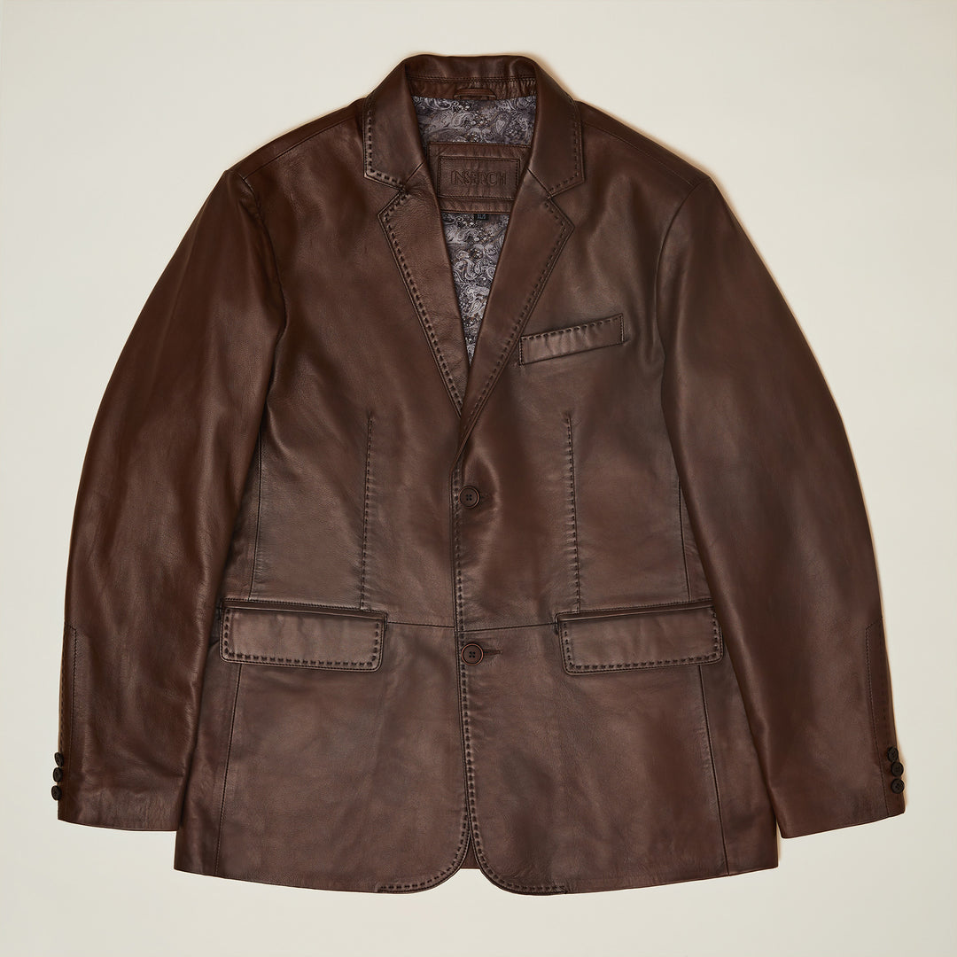 The Inserch Leather Blazer 600-104 Cognac by Inserch features a modern fit, notch lapels, two front buttons, three pockets, and visible pique stitch detailing, displayed flat on a light background.