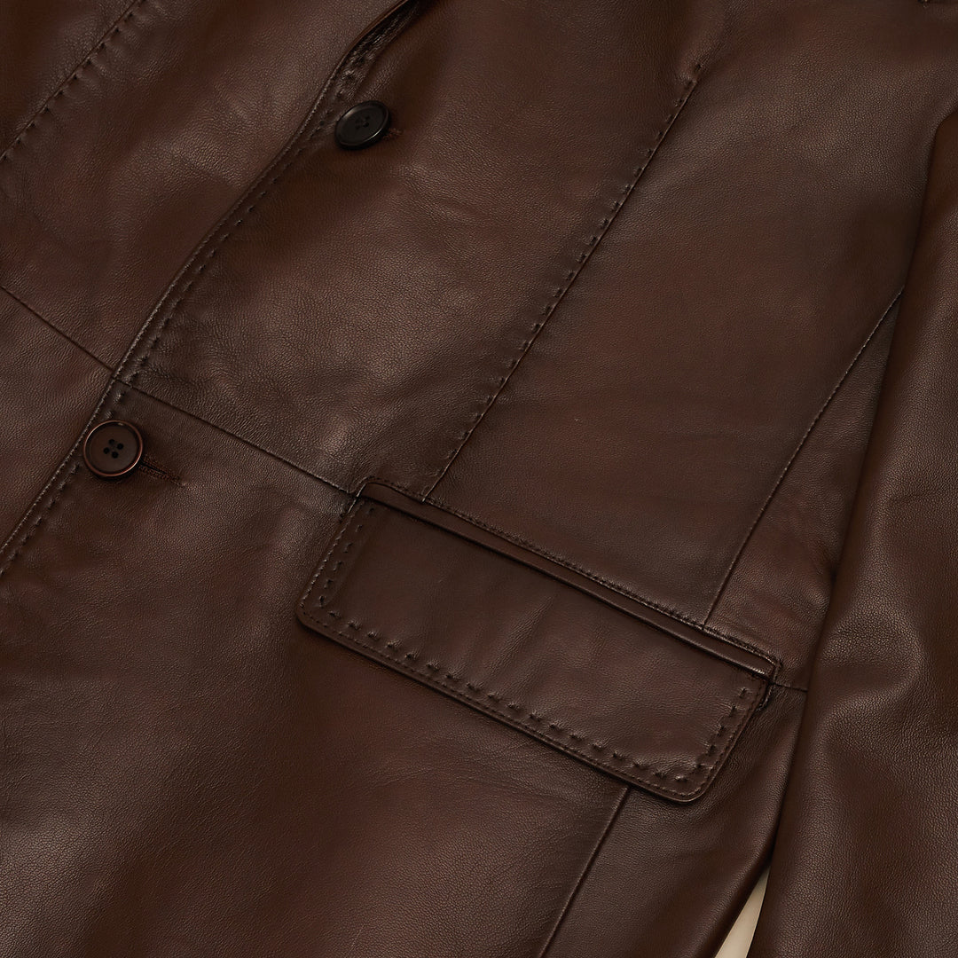 The Inserch Leather Blazer 600-104 Cognac by Inserch features a modern fit, notch lapels, two front buttons, three pockets, and visible pique stitch detailing, displayed flat on a light background.
