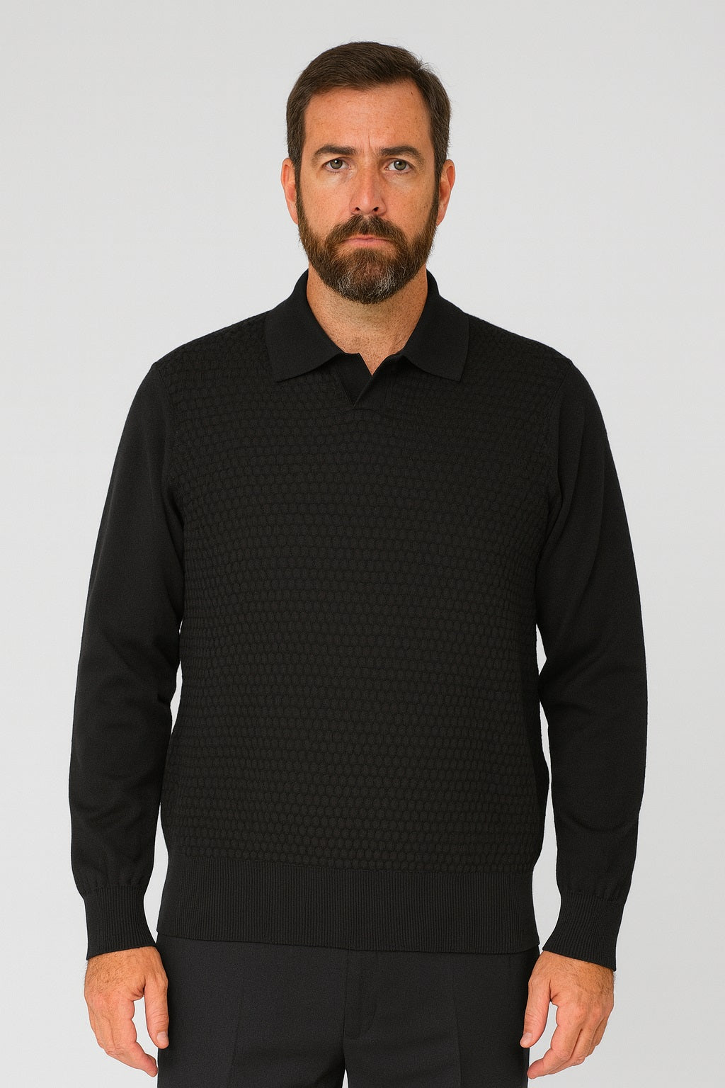 A man with short brown hair and a beard models the Bassiri Long Sleeve Collar Neck Black Sweater 640 by Bassiri over a black collared shirt, standing against a plain light gray background.