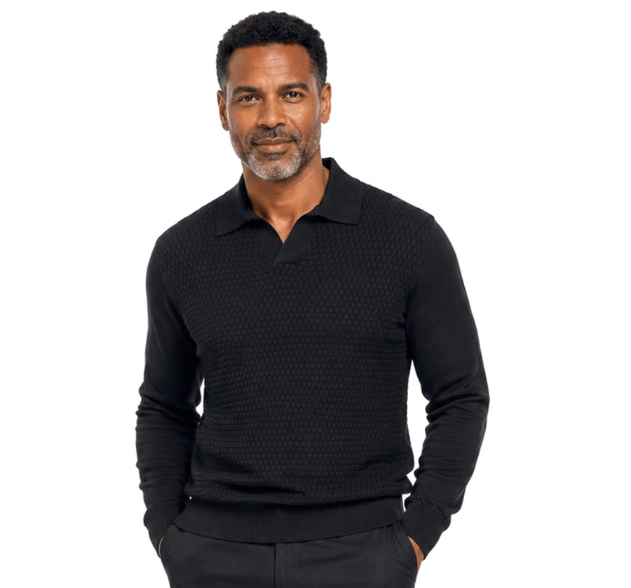 A man with short brown hair and a beard models the Bassiri Long Sleeve Collar Neck Black Sweater 640 by Bassiri over a black collared shirt, standing against a plain light gray background.