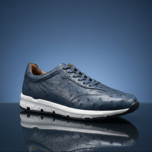 A Belvedere Shoe 10 in size 8.5 (FINAL SALE) by BELVEDERE is displayed on a wooden surface in a store setting. This dark blue textured sneaker features a white sole and is final sale—no returns or exchanges available.