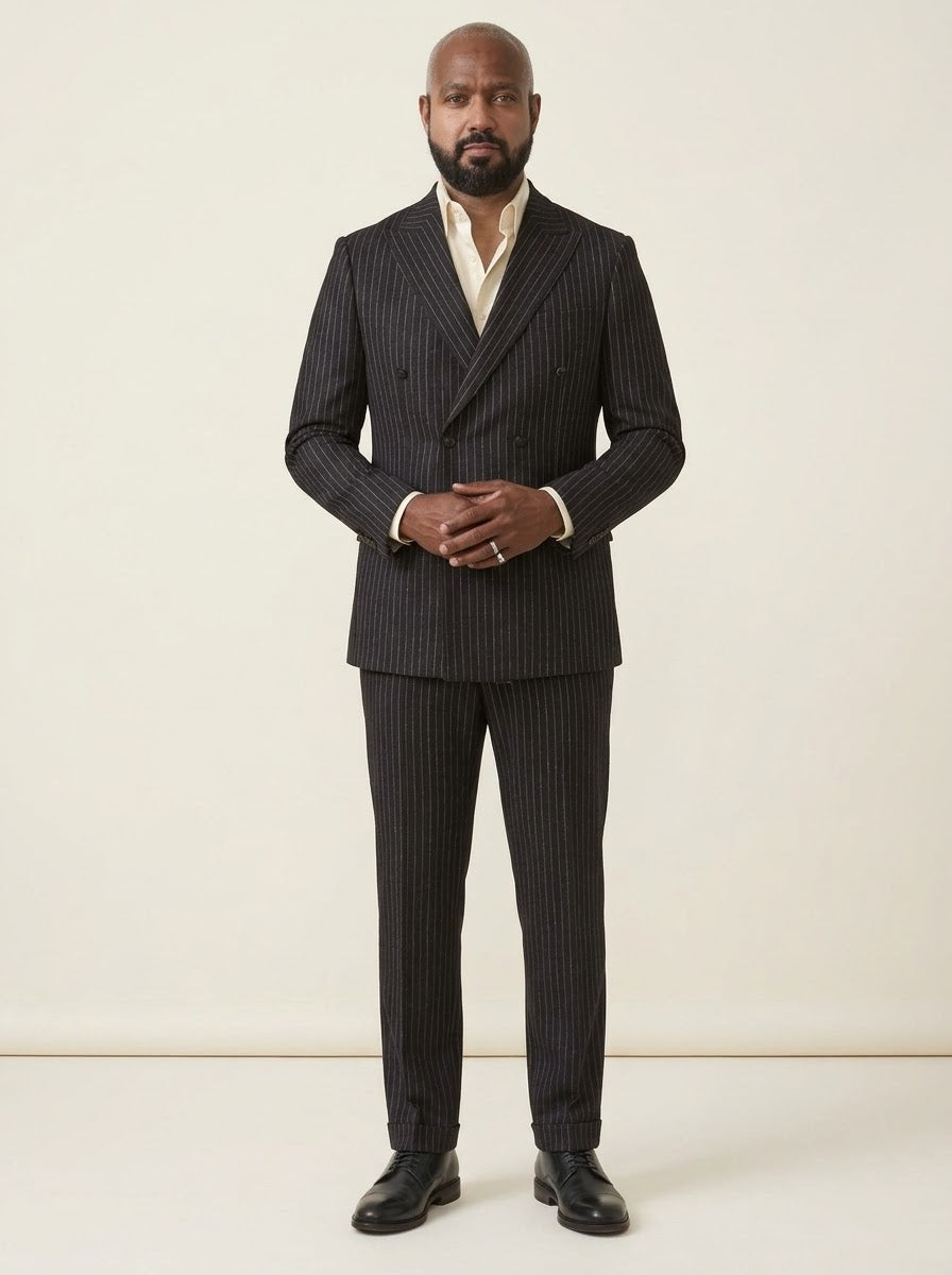 Man wearing the Inserch Wool Blend Flannel DB Stripe Suit SU660280-00001 Black and a light shirt, standing against a plain beige background.