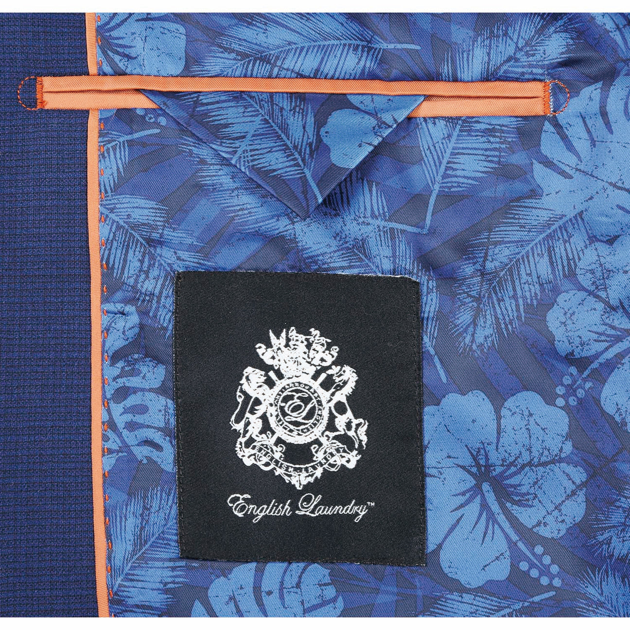 The ENGLISH LAUNDRY Blue Wool Suit EL82-22-411 by English Laundry, with its slim-fit design, is stylishly displayed on a mannequin alongside a crisp white shirt and an orange patterned tie.