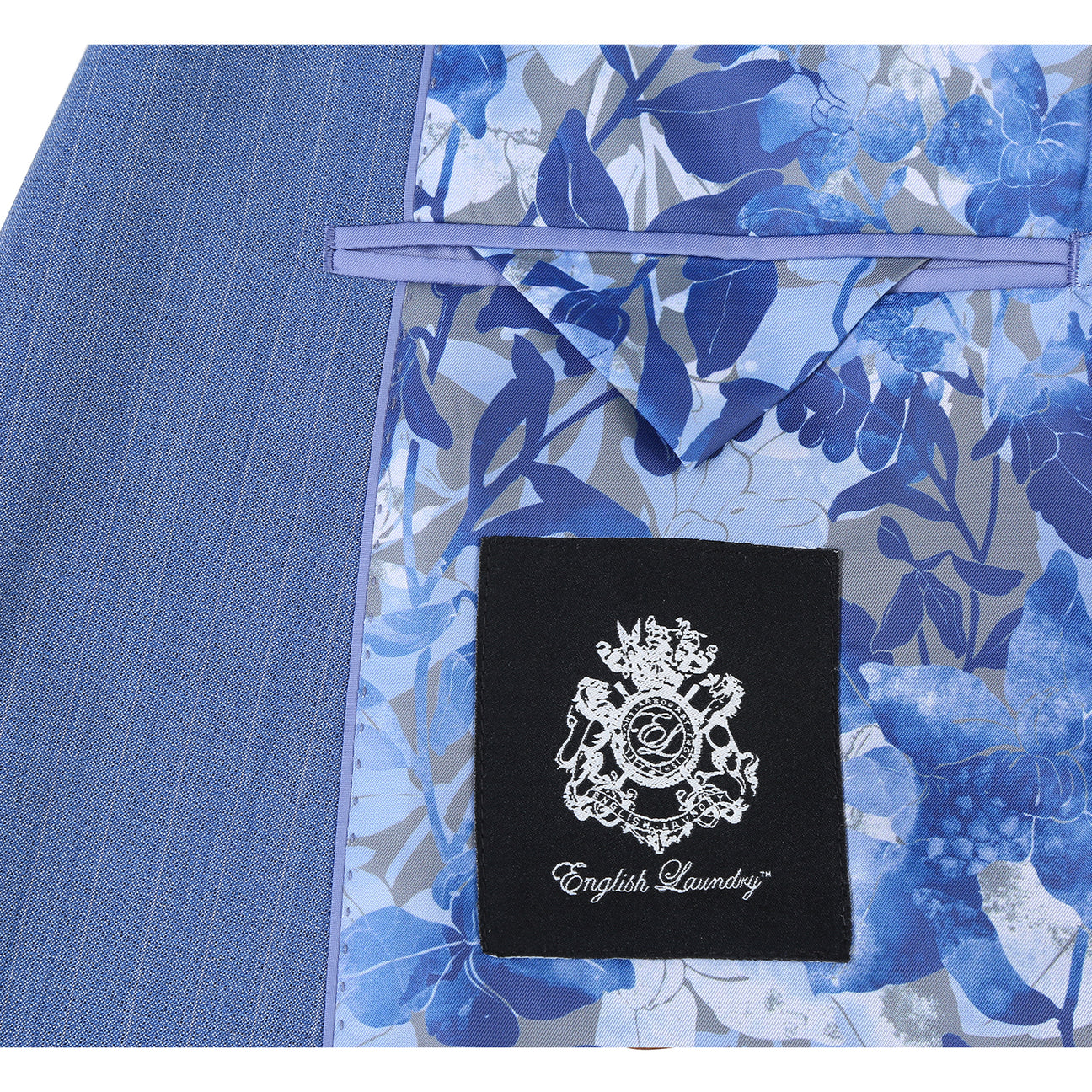 The ENGLISH LAUNDRY Light Blue Wool Suit EL92-33-412 by English Laundry features a slim fit, peak lapels, and pinstripes; displayed on a mannequin with a white dress shirt and blue patterned tie.