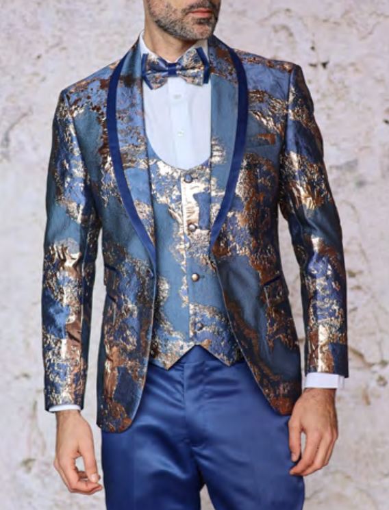 A man wearing the INSOMNIA DELMAS TEAL Suit from Insomnia, featuring gold patterns, a matching vest, and a bow tie, stands against a light background.