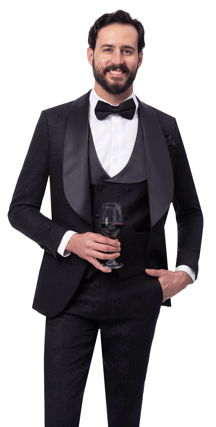 A man in the EJ Samuel Black Suit JP138 by EJ SAMUEL, featuring a classic black tuxedo jacket and bow tie, smiles at the camera holding a glass of red wine against a plain white background.