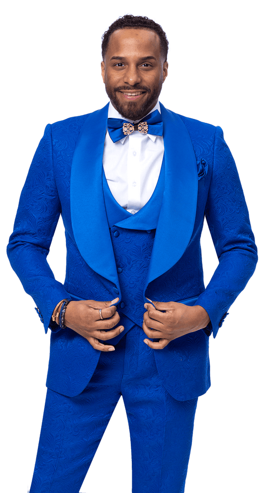 A man smiles wearing the EJ Samuel Royal Suit JP138, a vibrant blue 3-piece suit by EJ SAMUEL, complete with a matching vest and bow tie, hands holding the front of his jacket.