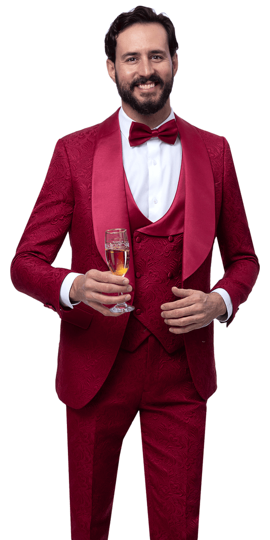 Man wearing the EJ Samuel Wine Suit JP138 by EJ SAMUEL, a patterned 3-piece tuxedo with matching vest and bow tie, holding a glass of champagne and smiling at the camera.