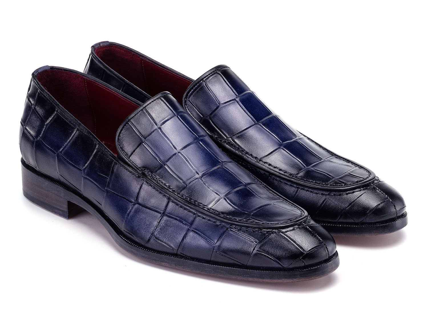 The Paul Parkman Croco Textured Leather Loafer Blue - 7339-BLU, a pair of blue men's loafers with crocodile texture, is shown on a white background—one shoe upright, the other leaning diagonally against it.