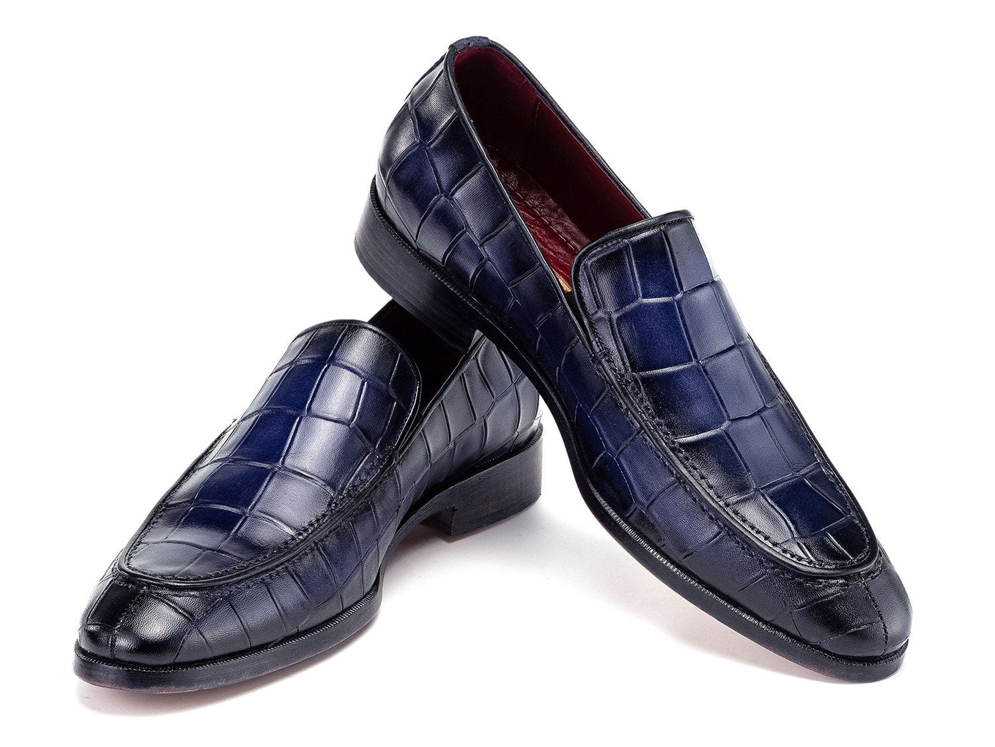 The Paul Parkman Croco Textured Leather Loafer Blue - 7339-BLU, a pair of blue men's loafers with crocodile texture, is shown on a white background—one shoe upright, the other leaning diagonally against it.