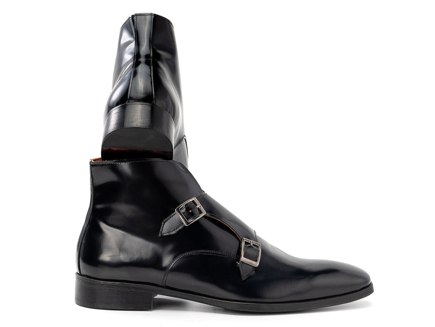 The Paul Parkman Double Monkstrap Ankle Boots in black polished leather (model 8154-BLP) feature side buckles; one men's boot stands upright while the other is balanced on top.