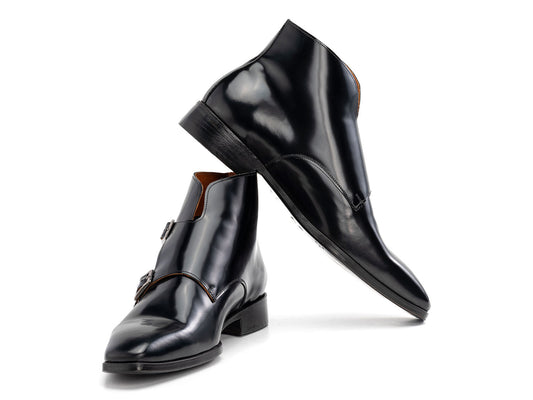 The Paul Parkman Double Monkstrap Ankle Boots in black polished leather (model 8154-BLP) feature side buckles; one men's boot stands upright while the other is balanced on top.