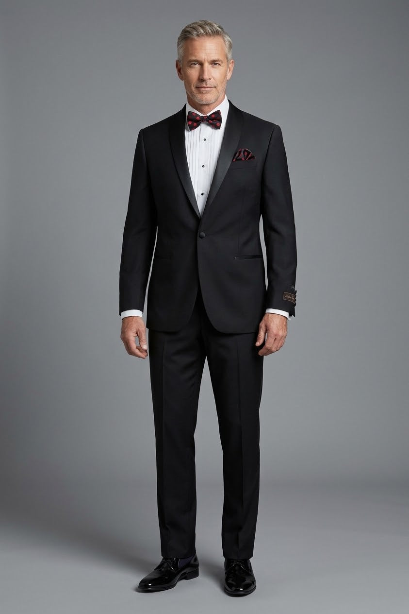 Introducing the Tiglio Luxe Beckham Black Tuxedo (Tig1001) by Tiglio. Expertly crafted from fine Italian wool, this tuxedo features a sophisticated satin lapel. Pair it with a crisp white shirt, a red and black polka dot bow tie, and a complementary pocket square for an ensemble that boasts a modern European fit with timeless elegance.