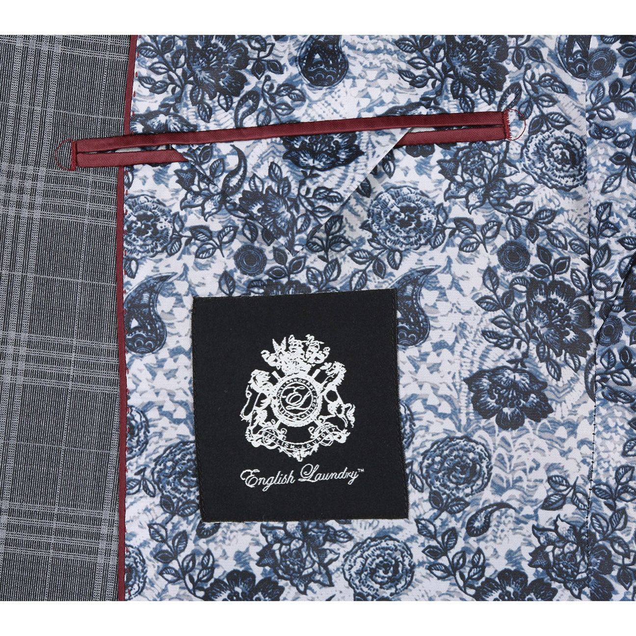 A slim fit jacket from English Laundry, specifically the ENGLISH LAUNDRY Gray Check Peak Wool Suit (EL72-58-093), featuring a peak lapel and two-button closure, elegantly complemented by a white shirt and an orange patterned tie, displayed on a mannequin.