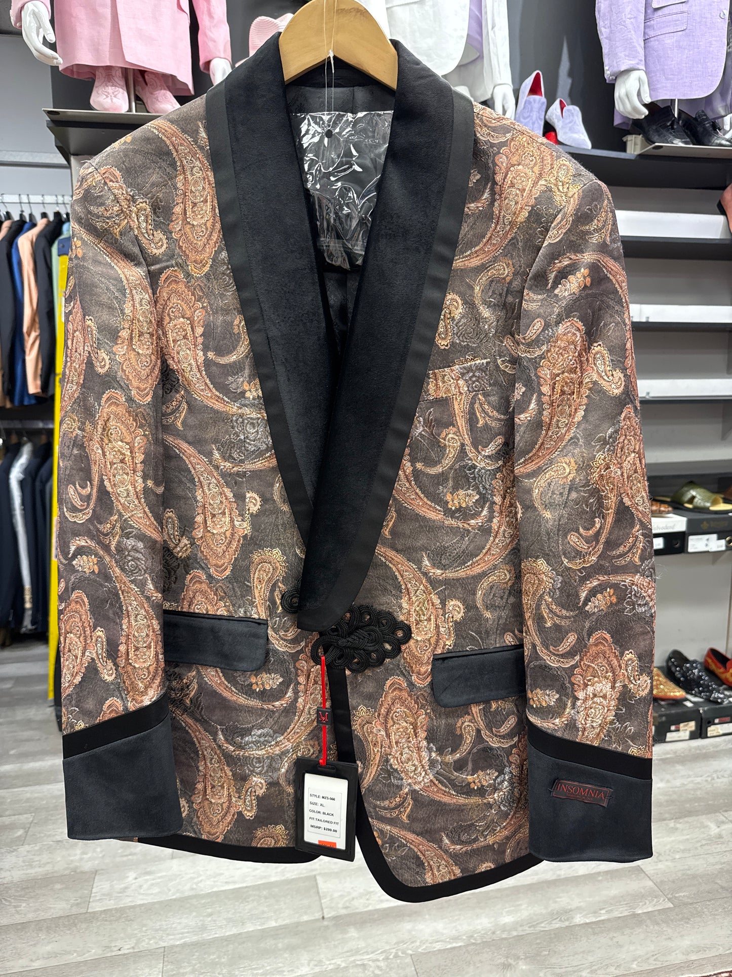 EJ SAMUEL JACKET 10 CLEARANCE — paisley-patterned blazer with black satin shawl collar and trim, displayed on a wooden hanger in a men's clothing store. Please note: final sale—no exchanges or returns.