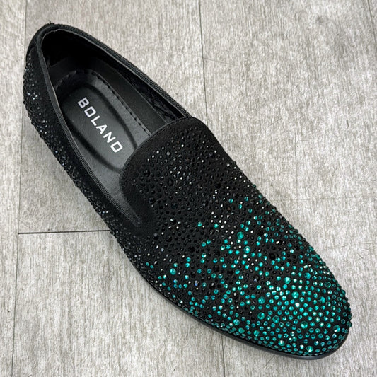 The Exclusive Formal Dress Shoe Green / Black ONYX by UNIQUE DESIGN MENSWEAR, crafted in Italy from genuine leather, dazzles with green and black rhinestones as it rests elegantly on a wooden floor.