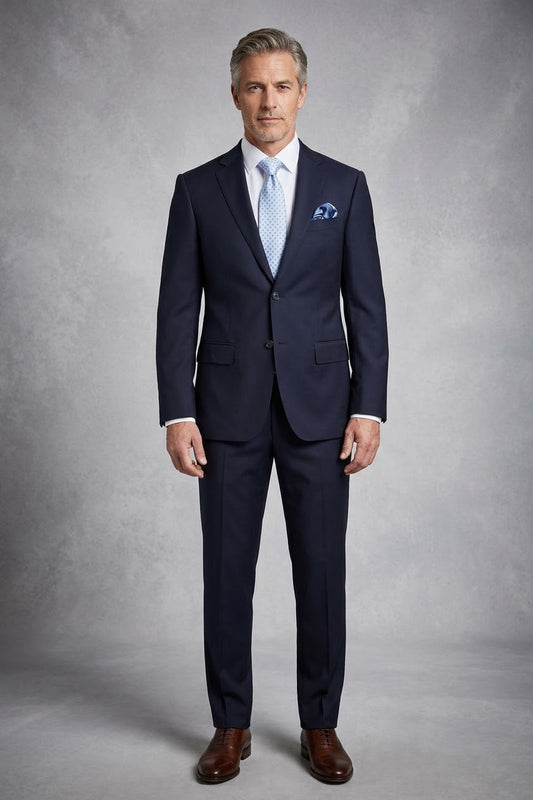 The Tiglio Luxe Novello Navy Blue Pure Wool Men’s Suit (TIG1002) by Tiglio Luxe is displayed on a mannequin with a light blue patterned tie, white dress shirt, and blue pocket square—an elegant choice in luxury men's clothing.