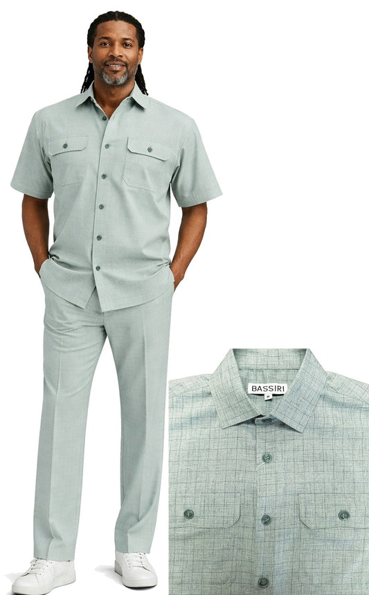 A man wears the Bassiri Teal 2pc Set A 144 by Bassiri—light teal short-sleeve button-up shirt with chest pockets and matching pants, styled with white sneakers; close-up highlights the shirt’s collar and detailed pockets.