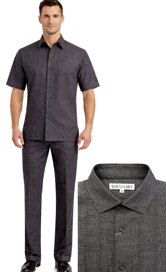 A man wears the Bassiri Charcoal 2pc Set A 146, featuring a short-sleeve button-up shirt and matching pants. The image also highlights the shirt's collar and the Bassiri brand label.
