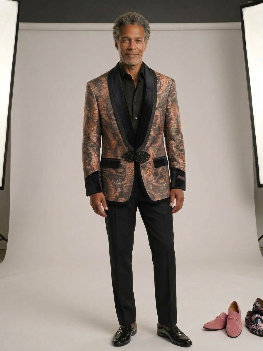 A man stands in a photography studio wearing the EJ SAMUEL Jacket 10 Size XL; pink loafers and floral boots—final sale, no returns—are on the floor nearby.