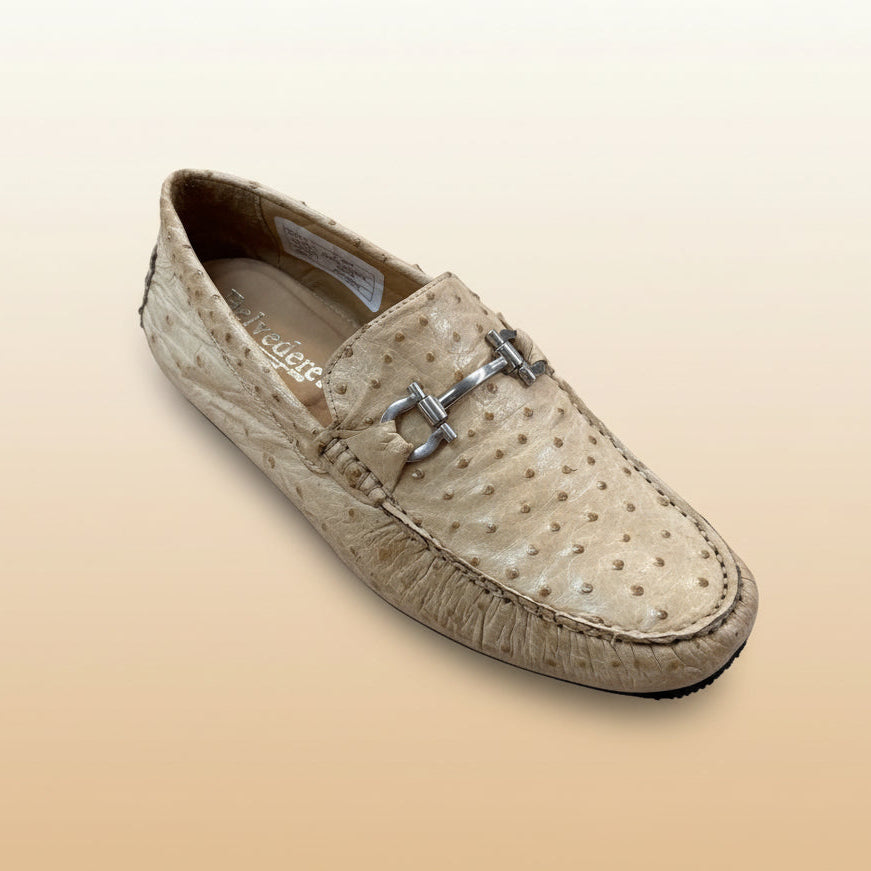 A BELVEDERE “Belvedere Shoe 11” ostrich leather loafer in tan, featuring a silver buckle detail, is displayed on a wooden surface. This item is FINAL SALE (size 8.5 only) and cannot be returned or exchanged.
