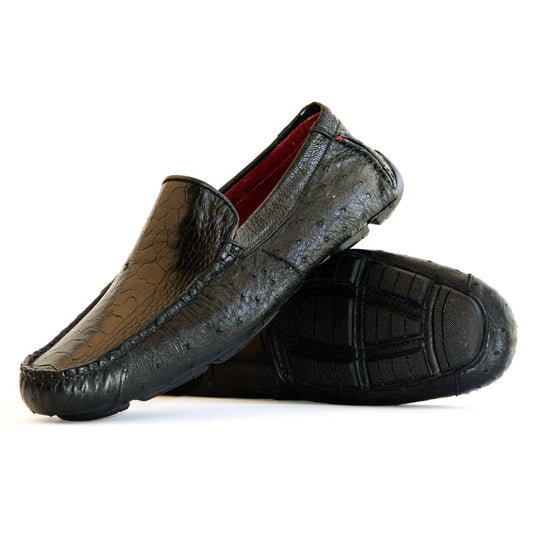 A pair of Marco Di Milano Alba Black luxury moccasin loafers—one upright and the other leaning against it—showcasing detailed stitching and a sole expertly crafted from genuine ostrich leather for an unmistakably exotic driver style.