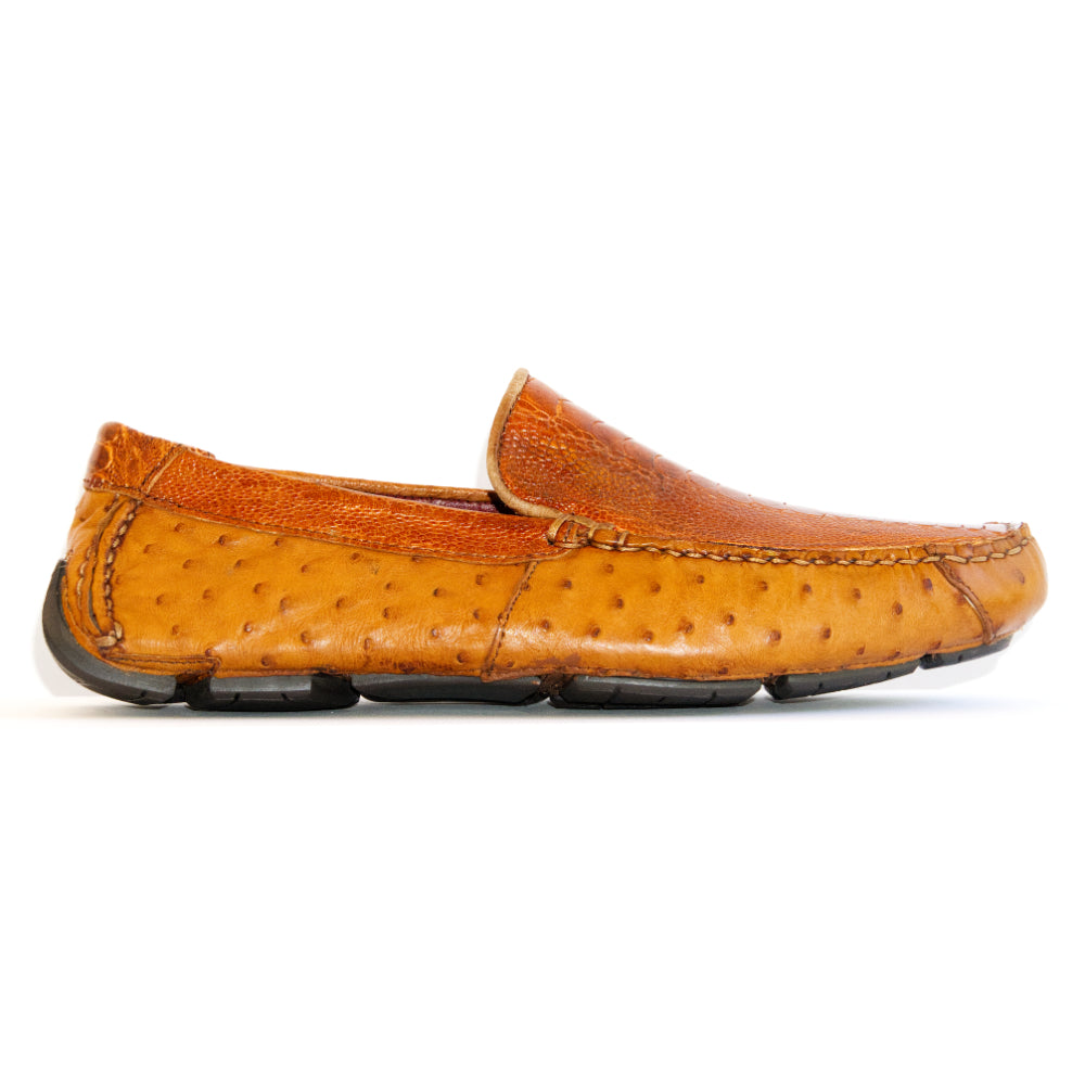 A pair of Alba Brandy luxury moccasin loafers by Marco Di Milano, crafted from genuine tan ostrich leather with a distinctive textured surface and black rubber soles—one shoe displayed upright and the other shown lying on its side.