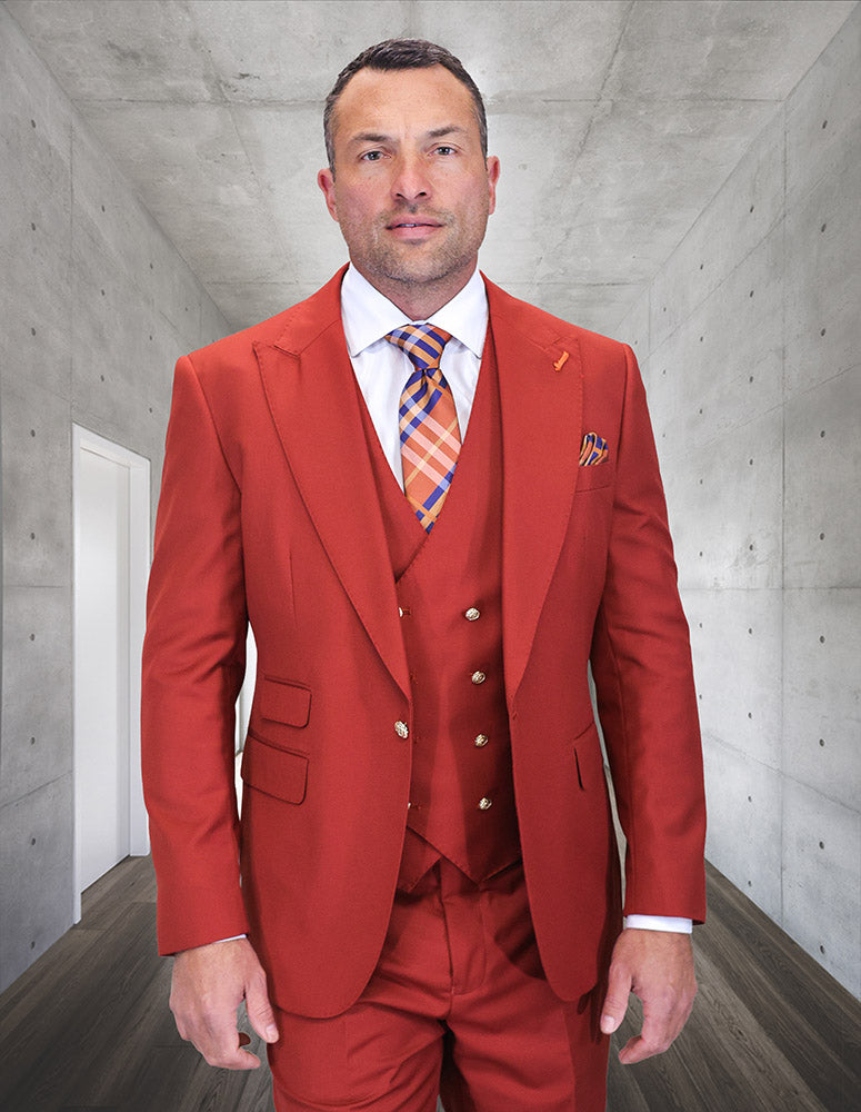 A man in the STATEMENT CLOTHING | AMIRI-BRICK suit by Statement Clothing with a patterned tie and modern fit stands in a sleek, concrete hallway.
