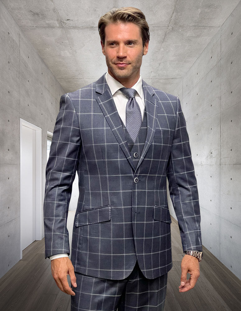 A man stands in a hallway wearing the STATEMENT CLOTHING | ANGEL-3-GRAY modern fit suit by Statement Clothing, paired with a white shirt and patterned tie.