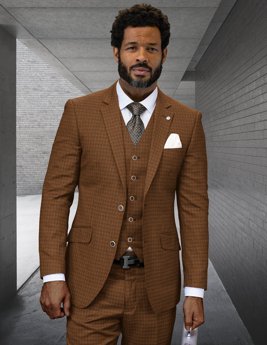 A man in a STATEMENT CLOTHING | ANGEL-4-COPPER modern fit Italian wool three-piece suit by Statement Clothing, with a white shirt and patterned tie, stands in a gray concrete hallway holding a piece of paper.