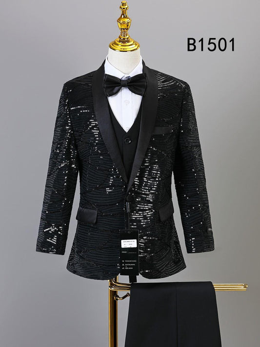The BOY SUIT 5-PC SET B1501 by Unique Design Menswear features a black sequin tuxedo jacket with satin lapels, white shirt, vest, black bow tie, and matching pants—perfect boys' formal wear. "B1501" appears in the background. Displayed on mannequin.