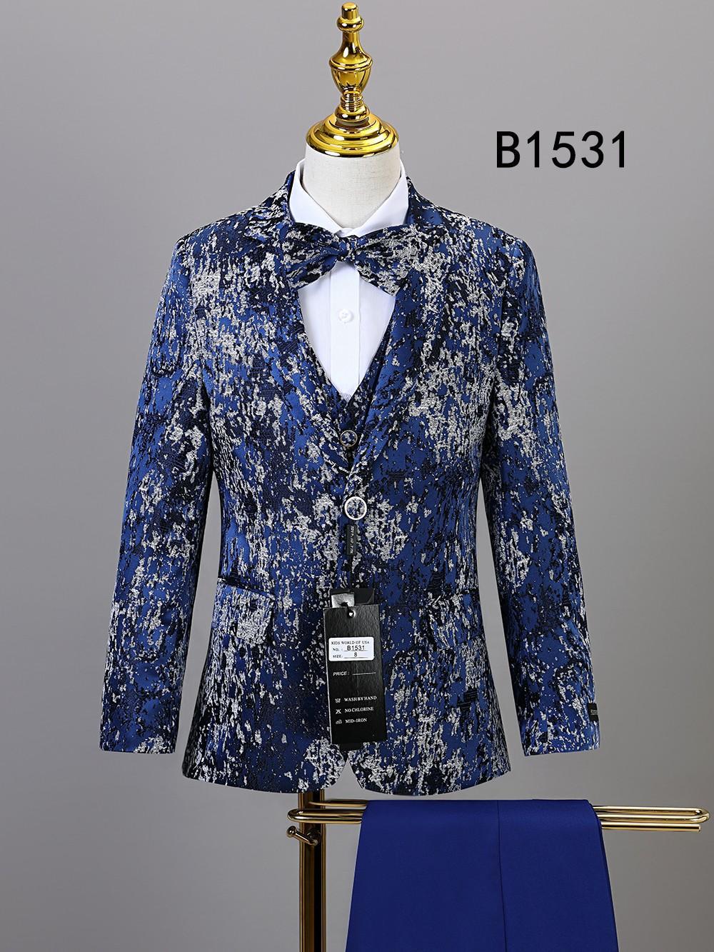 The Unique Design Menswear BOY SUIT 5-PC SET B1531 features a blue and silver patterned jacket with matching bow tie, shown on a mannequin with white shirt and blue trousers. The label "B1531" appears in the background.