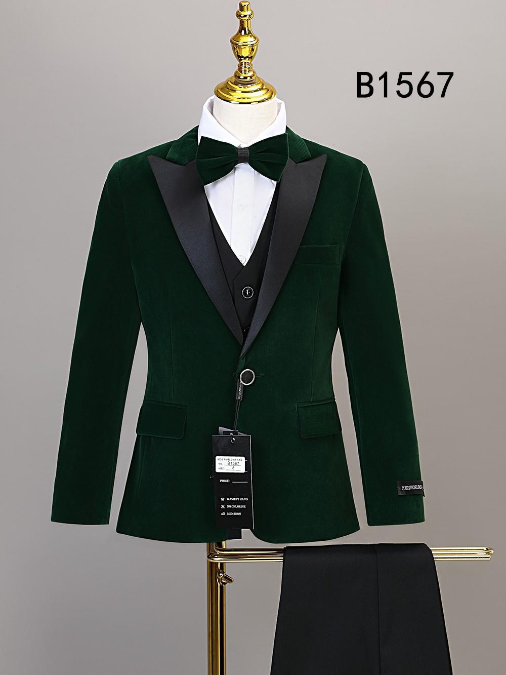 The Unique Design Menswear BOY SUIT 5-PC SET B1567, in dark green velvet with black satin lapels, includes a jacket, waistcoat, white dress shirt, and matching formal pants, all displayed together on a mannequin.