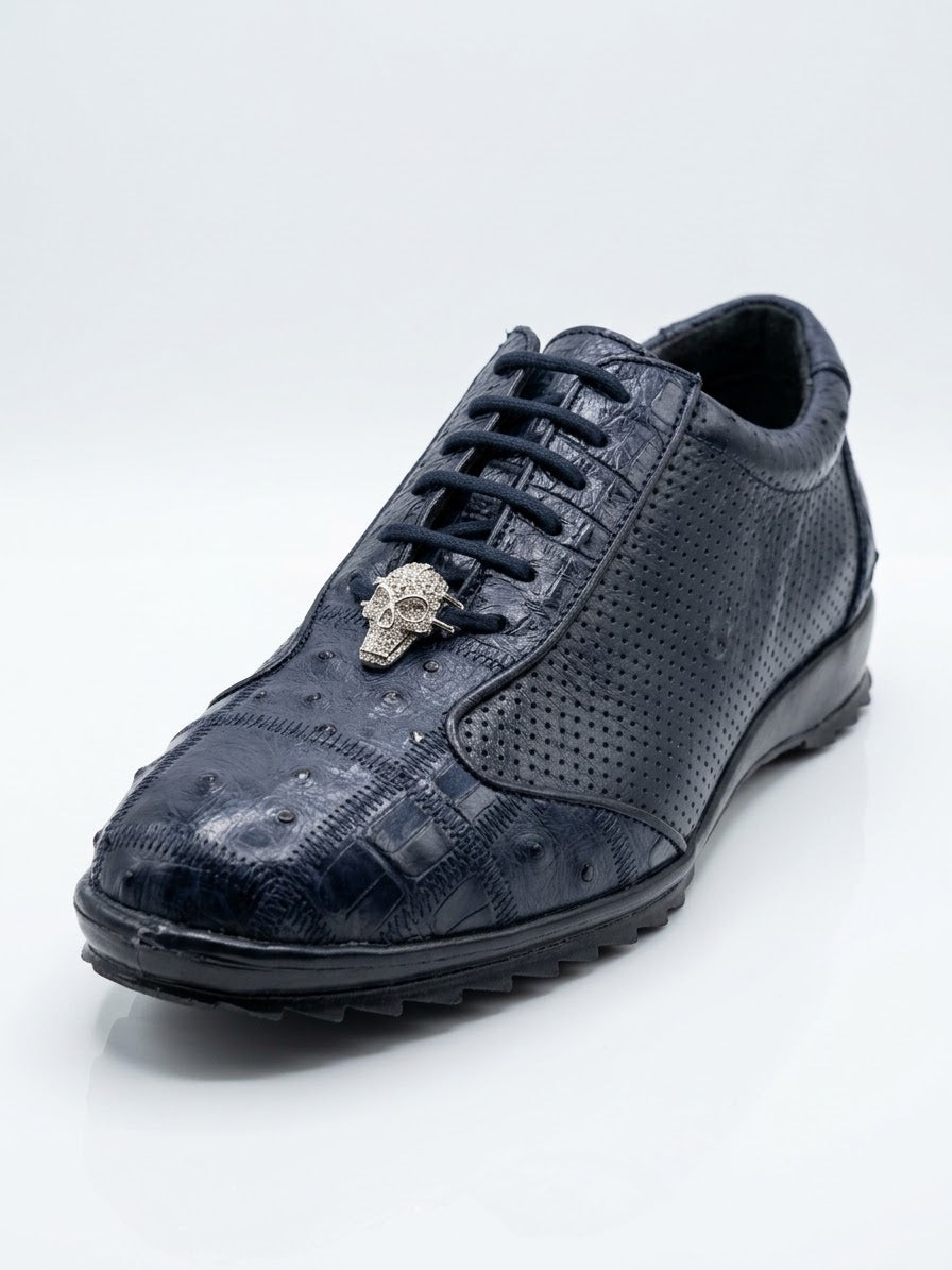 Introducing the Los Altos Avestruz Perforated Ostrich Lace Up Casuals in Navy by Los Altos—a navy blue sneaker crafted from genuine ostrich leather, featuring a textured finish, perforated side panel accents, and a metallic skull ornament on the laces, photographed against a white background.