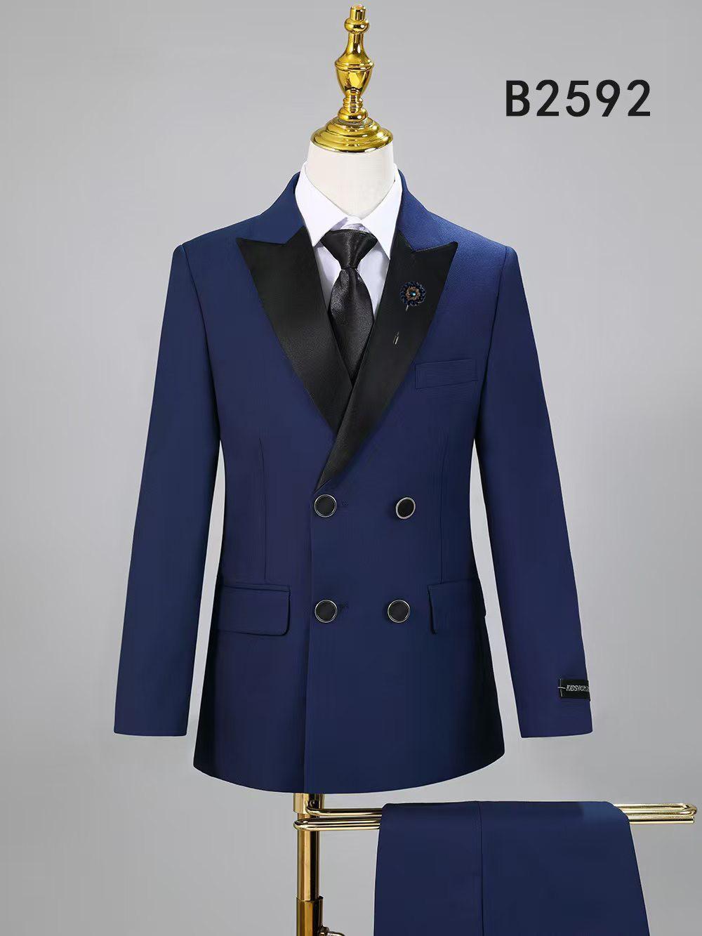 The BOY SUIT 5-PC SET B2592 by Unique Design Menswear features a blue double-breasted jacket with black satin lapels, black buttons, and matching trousers, displayed on a mannequin.