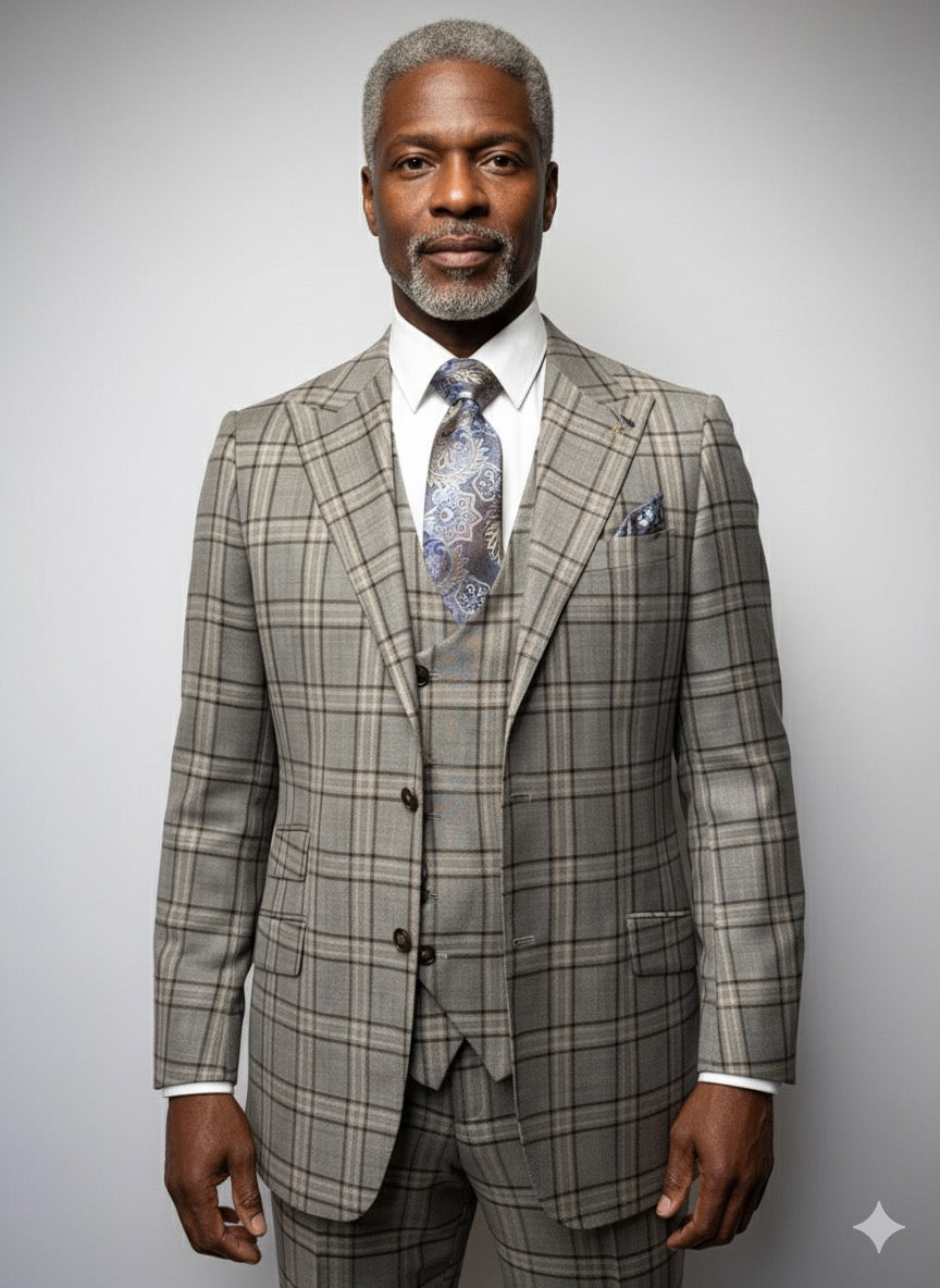 A man with gray hair and beard wears a brown plaid Tiglio Luxe Prosecco Modern Fit suit and vest, paired with a white shirt and patterned tie, standing against a plain light background.