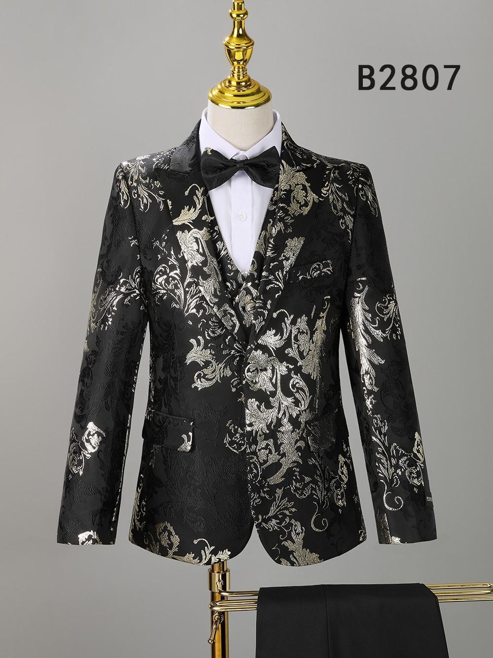 BOY SUIT 5-PC SET B2807 by Unique Design Menswear: black jacket with metallic silver floral pattern, shown on a mannequin with white shirt and black bow tie. Ideal for special occasions. "B2807" appears in the top right corner.