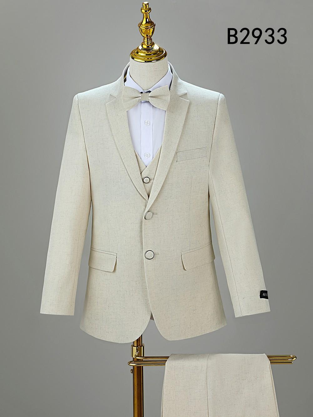 The Unique Design Menswear BOY SUIT 5-PC SET B2933 includes a cream-colored jacket, pants, vest, bow tie, and white shirt. Displayed on a stand.