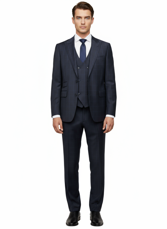 A man stands facing forward against a plain white background, wearing the Tiglio Luxe Black With Blue Windowpane Prosecco Modern Fit Pure Wool Suit and Vest (TL2004) by Tiglio Luxe, paired with a white dress shirt, navy tie, and black dress shoes.
