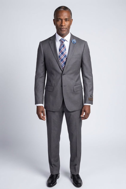 The Tiglio Luxe Novello Medium Gray Pure Wool Men’s Suit TIG1008 features a white dress shirt, striped tie, blue flower lapel pin, and a left sleeve label—Tiglio Luxe luxury fashion for men, displayed on a headless mannequin.