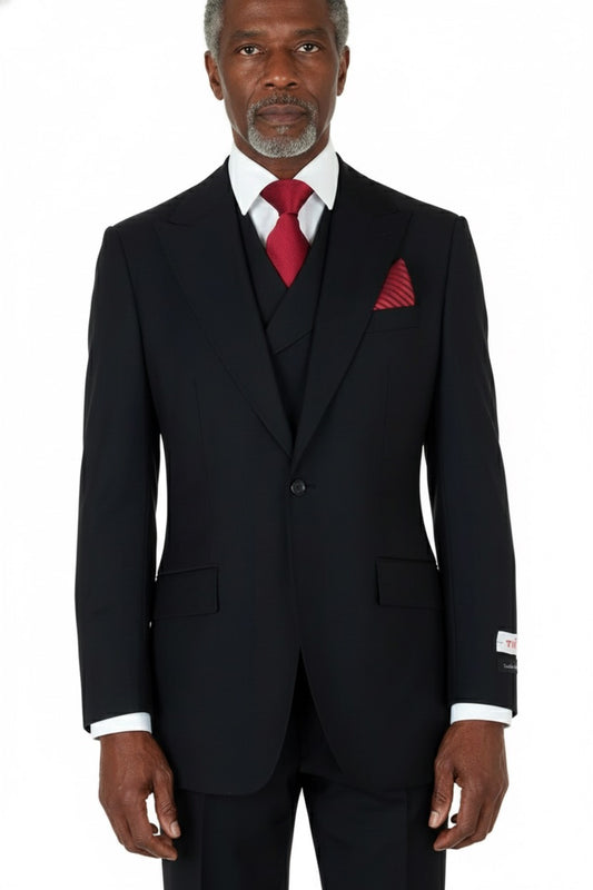 A Tiglio Rosso San Giovesse Solid Black TIG1001 suit elegantly displayed on a mannequin, featuring a striking black fabric paired with a red tie and pocket square. The ensemble's wide leg fit brings an air of sophistication to the classic look.