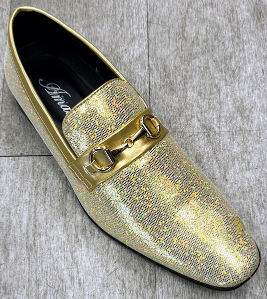 A shimmering yellow SUTTON loafer by UNIQUE DESIGN MENSWEAR, crafted from genuine leather with a metallic buckle detail, rests elegantly on a gray tile floor.