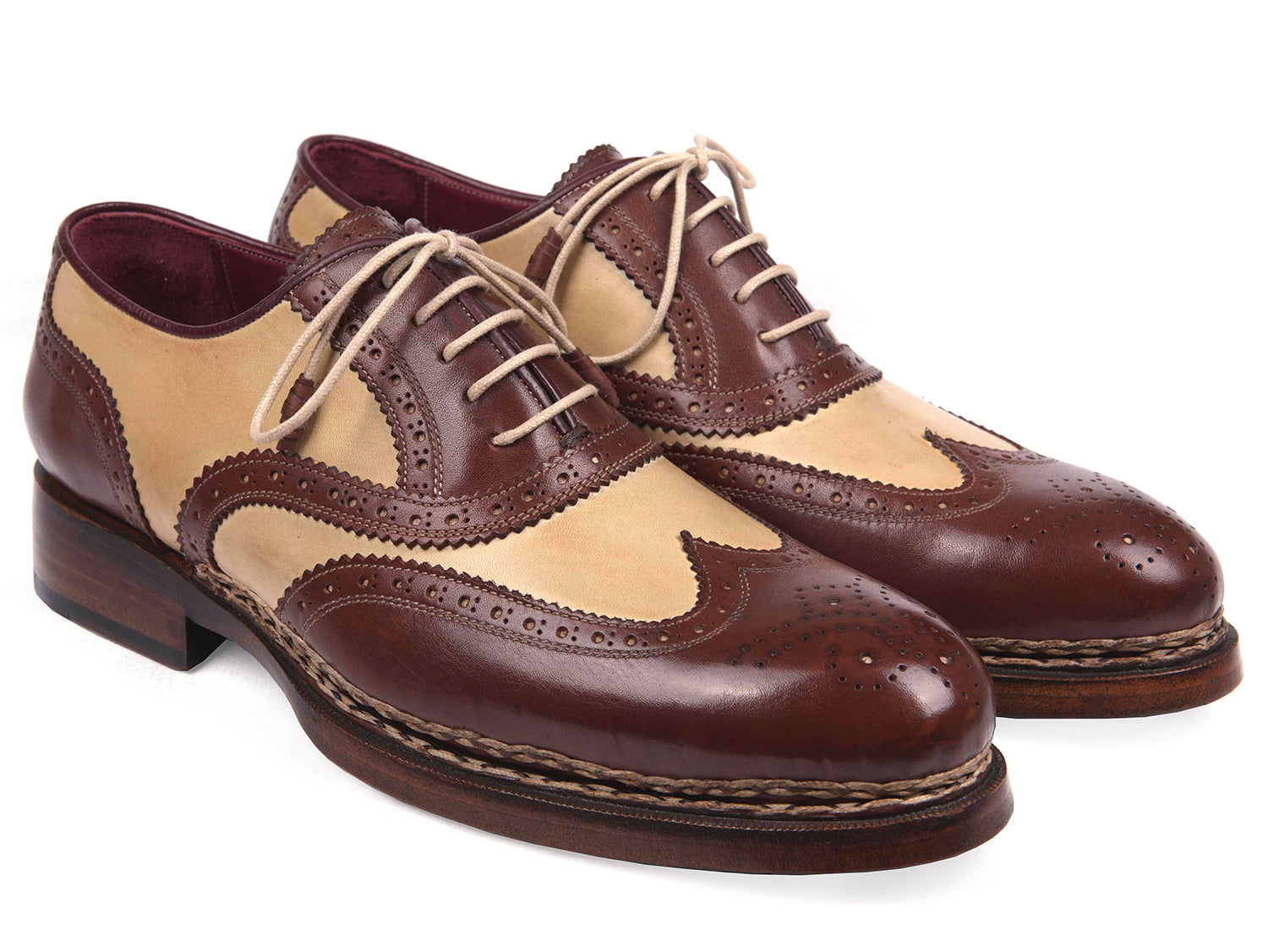 The Paul Parkman Triple Leather Sole Goodyear Welted Wingtip Brogues - 095BEJ are dual-tone brown and beige calfskin shoes with lace-up closures, decorative perforations, and classic brogue detailing.