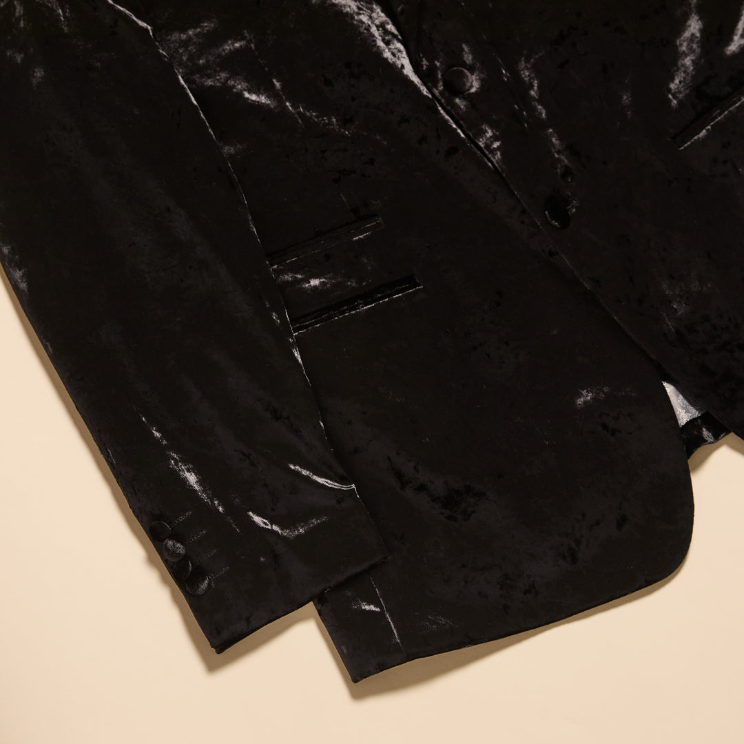 A man wearing the Inserch Crushed Velvet Suit BL008-00001 Black over a white turtleneck and modern fit pants, standing against a plain beige background.