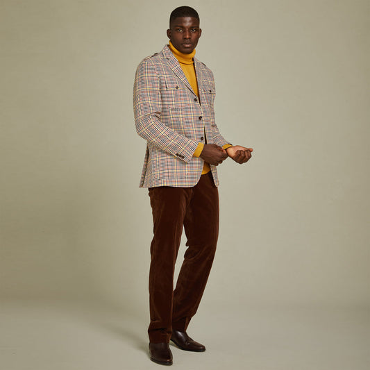 A man stands against a plain background wearing the Inserch Mini-Houndstooth Blazer BL265-64 Mocha, paired with a yellow turtleneck, brown pants, and brown shoes.