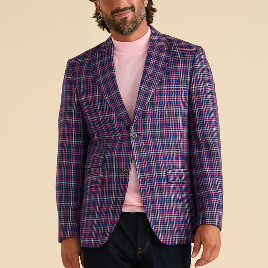 A man wearing a pink turtleneck and the Inserch Micro Houndstooth Check Peak Lapel Blazer BL266-126 in purple stands against a plain beige background.