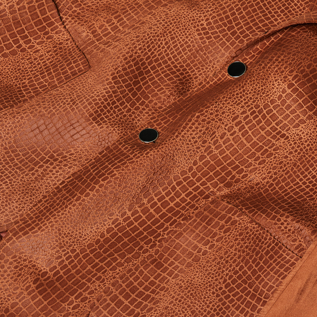 A man in an Inserch Suede Snake Skin Blazer BL268-104 Cognac over a cream turtleneck and blue, orange, and white plaid pants stands against a beige background.